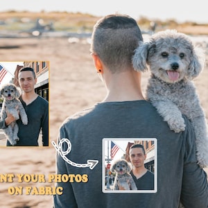 May include: A grey long-sleeved top with a square photo print on the back. The print shows a man holding a small grey dog. The text "PRINT YOUR PHOTOS ON FABRIC" is at the bottom.