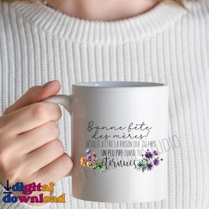 May include: White ceramic mug with a black design that says "Bonne fête des mères!"  "DÉSOLÉE D'ÊTRE LA RAISON QUE TU FAIS UN PEU PIPI QUAND TU" and "eternuess". The design also includes colorful flowers.