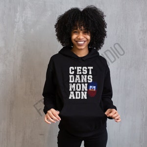 May include: Black hoodie with a white graphic that says "C'est Dans Mon ADN" with a Haitian flag graphic.