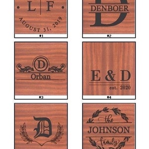 May include: A collection of custom engraving options on wooden plaques. Designs include names, initials, dates, and family names. The text is in a dark color, and the wood has a reddish-brown tone.