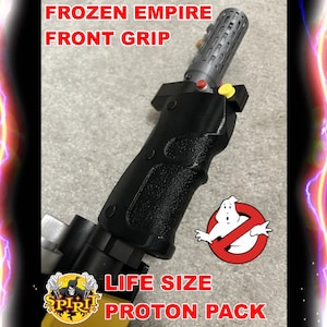 May include: A black plastic front grip for a Ghostbusters proton pack. The grip has a textured surface and a yellow button. The text "FROZEN EMPIRE FRONT GRIP" is visible at the top of the image. The text "LIFE SIZE PROTON PACK" is visible at the bottom of the image.