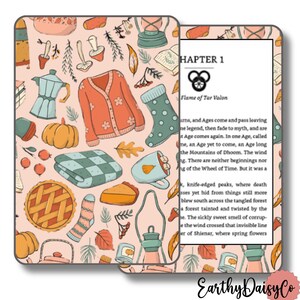 May include: A pink e-reader cover with a pattern of autumn illustrations, including a sweater, pumpkin, and pie. The open e-reader shows text from "Chapter 1: Flame of Tar Valon."