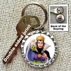 May include: A silver bottle cap keychain with a double-sided print. One side features a cartoon image of the Evil Queen from Snow White holding a poisoned apple. The other side says "Back of the Keyring".
