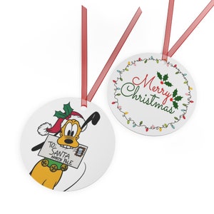 Può includere: Due decorazioni natalizie rotonde. Una presenta un'immagine di cartone animato di Pluto il cane che indossa un cappello da Babbo Natale e tiene una lettera indirizzata a Babbo Natale al Polo Nord. L'altra decorazione ha uno sfondo bianco con un ramo di agrifoglio verde e il testo "Buon Natale" in un carattere corsivo circondato da una ghirlanda di luci colorate.