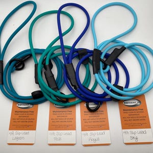 Könnte beinhalten: Eine Auswahl an 122 cm langen Führleinen in verschiedenen Blau- und Türkistönen. Jede Leine hat einen schwarzen Griff und ein Etikett mit Produktinformationen. Die Farben sind Lagoon, Teal, Royal und Sky.