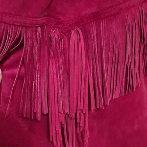 May include: A magenta suede skirt with a fringe trim.