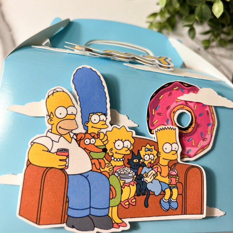 Puede incluir: Una familia de dibujos animados azul y amarilla, incluyendo a Homer, Marge, Bart, Lisa y Maggie Simpson, est&aacute;n sentados en un sof&aacute; marr&oacute;n. El sof&aacute; est&aacute; decorado con una rosquilla rosa con chispas. El fondo es un cielo azul claro con nubes blancas.