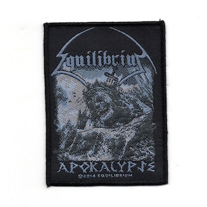 Può includere: Toppa ricamata nera e grigia con il nome della band "Equilibrium" e il titolo dell'album "Apokalypse" in un font gotico. La toppa presenta un'immagine oscura e ombrosa di una figura con una spada.