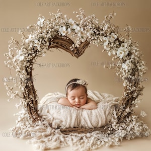 Pode incluir: Um bebê recém-nascido está dormindo em uma cesta branca tecida decorada com flores brancas. A cesta é cercada por uma coroa de flores brancas e galhos. O fundo é de cor marrom claro.