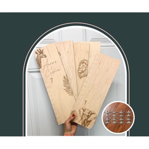 Peut inclure: Quatre tableaux de croissance en bois avec des illustrations d'animaux, dont un tableau portant les noms "Aurora & Caspian". Les tableaux sont marqués de nombres de 1 à 18.