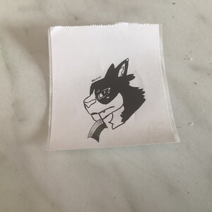 以下が含まれることがあります： 黒色の眼帯をした犬の頭の白黒の線画。犬は左を見ています。