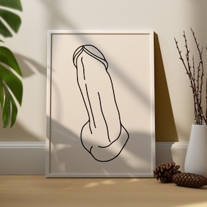 May include: A black and white line drawing of a person's body, with the head and arms obscured, printed on a cream-colored background. The print is framed in a white frame.