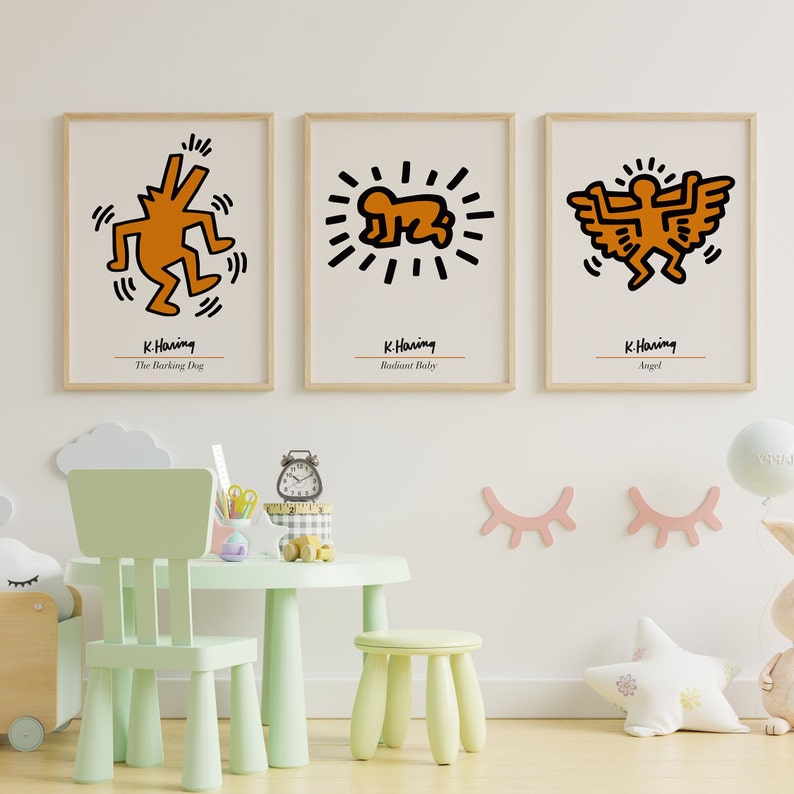 May include: Three framed prints of Keith Haring artwork. The prints are in a minimalist style with white backgrounds and black outlines. The artwork features a barking dog, a radiant baby, and an angel. The prints are titled "The Barking Dog", "Radiant Baby", and "Angel".
