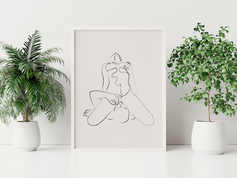 Peut inclure: Un dessin au trait noir et blanc d'une personne assise, les jambes crois&eacute;es. Le dessin est sur fond blanc et est encadr&eacute; d'un cadre blanc.