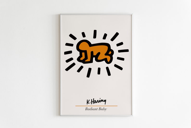 May include: A framed print of a black and orange illustration of a baby with a radiating sunburst around it. The print is titled "Radiant Baby" and signed "K. Haring".