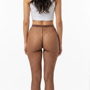 May include: A white sleeveless crop top paired with brown fishnet tights featuring a diamond-shaped mesh pattern and a solid brown waistband. The hosiery covers the legs from the waist down to the feet, showcasing a consistent brown tone.