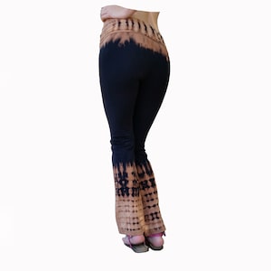 May include: Black flared pants with a brown tie-dye pattern at the waistband and bottom of the legs.