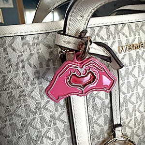 May include: A white ceramic mug with a black handle and the text "But First, Coffee" in a bold, black font. The mug is set against a blurred background, suggesting a cozy setting.