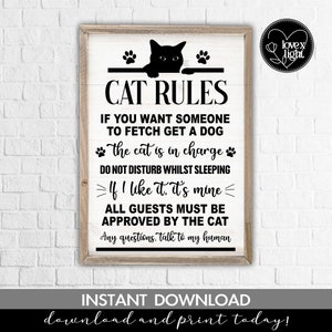 May include: Black and white printable sign with the text "CAT RULES" and a black cat peeking over a bar with paw prints. The text reads "If you want someone to fetch get a dog. The cat is in charge. Do not disturb whilst sleeping. If I like it, it's mine. All guests must be approved by the cat. Any questions, talk to my human."