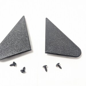 May include: Two black plastic triangular pieces with a textured surface and four black screws.