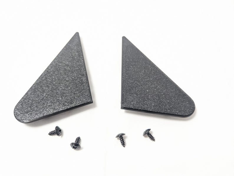 May include: Two black plastic triangular pieces with a textured surface and four black screws.