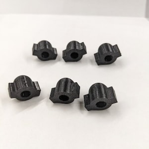 May include: Six black plastic knobs with a rounded top and a flat bottom. The knobs have a textured surface and are designed for use with a variety of applications.