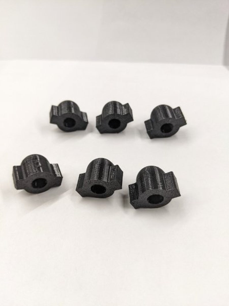May include: Six black plastic knobs with a rounded top and a flat bottom. The knobs have a textured surface and are designed for use with a variety of applications.