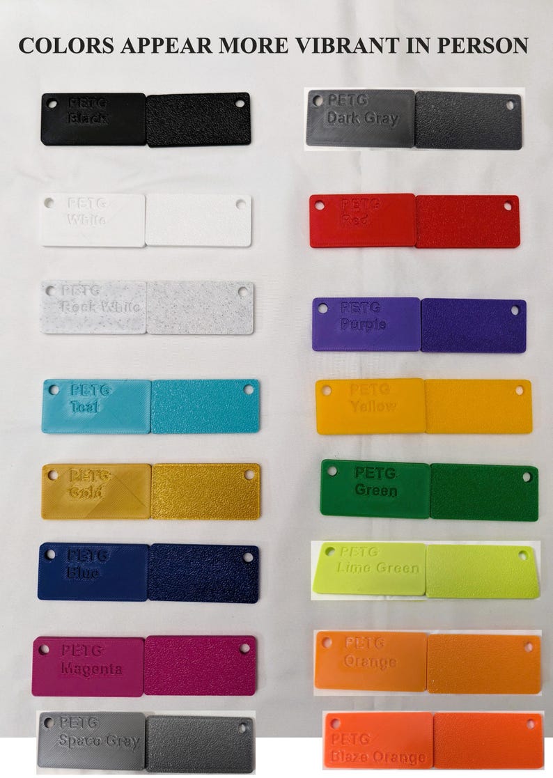 May include: A collection of 14 small plastic squares, each a different color, with the words "PETG" and the color name printed on each square. The colors include black, dark gray, white, red, rock white, purple, teal, yellow, gold, green, blue, lime green, magenta, orange, space gray, and blaze orange.