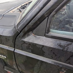 May include: A black Jeep Cherokee Sport with a silver trim around the windows and the words "Cherokee Sport" on the side.
