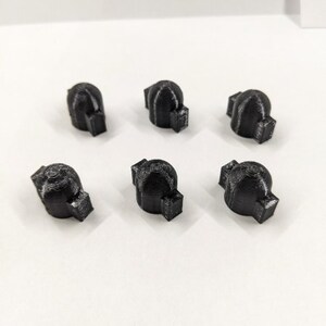 May include: Six black plastic knobs with a textured surface. The knobs have a rounded top and a flat bottom.