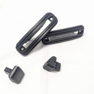 May include: Four black plastic pieces, two long rectangular pieces with a slot in the middle, and two smaller rectangular pieces.