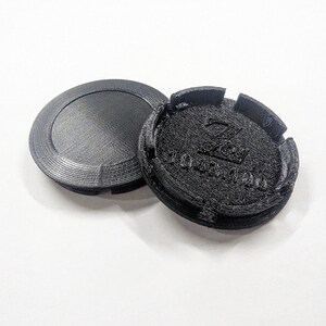 May include: Two black plastic wheel covers with a raised logo that says "ZOO YORK" in a stylized font.