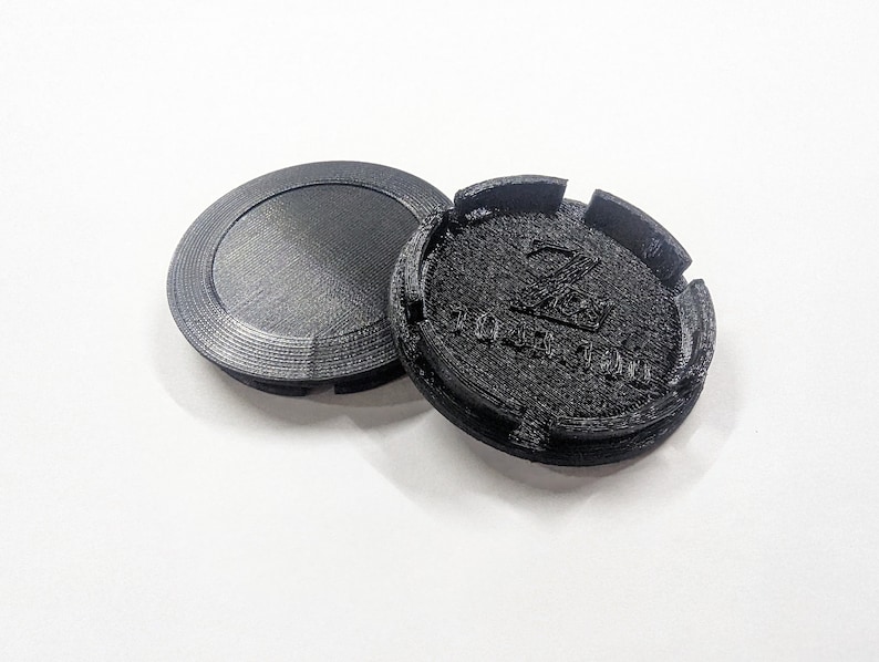 May include: Two black plastic wheel covers with a raised logo that says "ZOO YORK" in a stylized font.