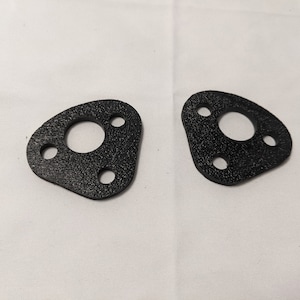 May include: Two black rubber gaskets with three holes each. The gaskets are shaped like a triangle with a rounded edge.