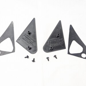 May include: Four black plastic pieces for a car's side view mirror, with two screws.