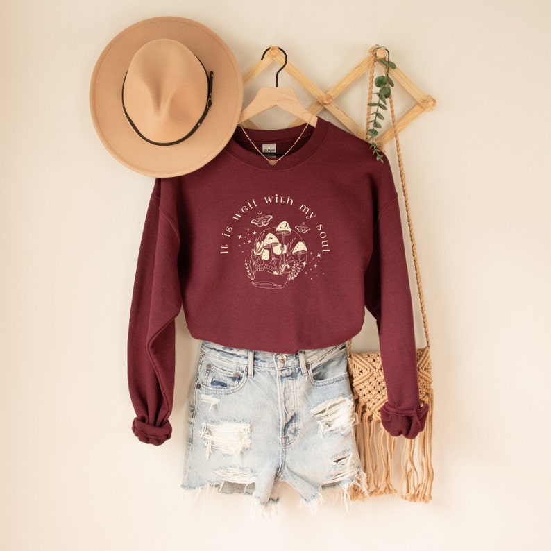 May include: Burgundy sweatshirt with a white graphic of mushrooms and the text "It is well with my soul".