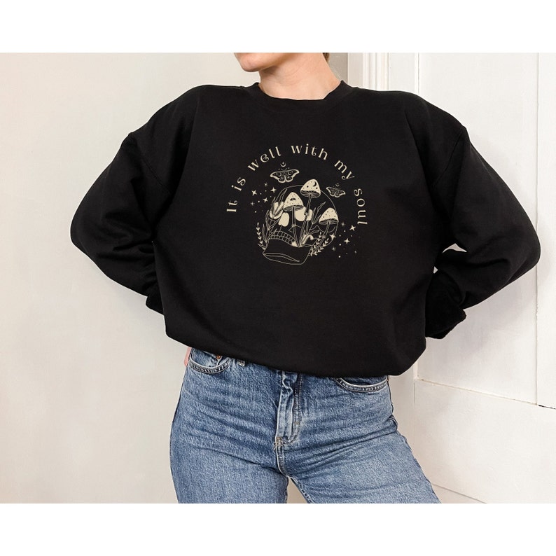 May include: Black sweatshirt with a graphic of a skull with mushrooms growing out of it. The text "It is well with my soul" is written around the skull.