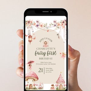 May include: A smartphone displays a fairy-themed birthday invitation. The invitation features floral accents, a mushroom house, and the text "CHARLOTTE'S fairy first BIRTHDAY." The date is Saturday, June 2025, at 2 PM.