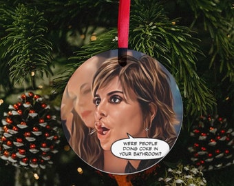 Peut inclure: Boule de Noël ronde avec une illustration de dessin animé d'une femme avec une expression surprise. La boule a une bulle de dialogue blanche avec le texte "Were people doing coke in your bathroom?"