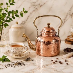 Chaleira de cobre puro com alça de latão, feita à mão com acabamento martelado, ideal para decoração de cozinha e preparo de café.