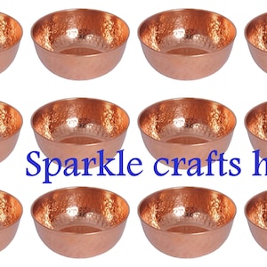 May include: Set of eight hammered copper bowls. The bowls are a warm copper colour and have a hammered texture. The bowls are arranged in two rows of four. The bowls are perfect for serving snacks, dips, or desserts.