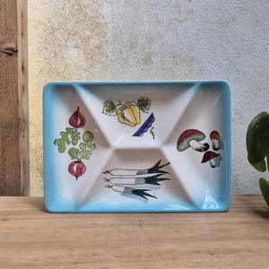 Könnte beinhalten: Eine blaue und weiße Keramik-Servierplatte mit vier Abschnitten. Jeder Abschnitt zeigt eine andere Gemüseillustration: eine rote Rübe, eine gelbe Paprika, grüne Zwiebeln und rote Pilze.