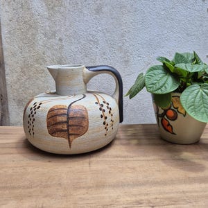 May include: A set of three ceramic mugs with a speckled, matte finish. The mugs are in shades of cream, light gray, and dark gray. Each mug has a simple, minimalist design, perfect for coffee or tea.