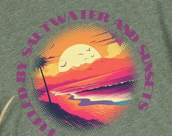 May include: Green t-shirt with a graphic of a sunset over the ocean and the text "Tulips, Saltwater and Sunsets".