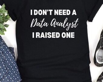 May include: Black t-shirt with white text that reads "I don't need a Data Analyst I raised one".