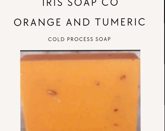 May include: Orange and turmeric cold process soap bar from Iris Soap Co. The soap is a bright orange colour with flecks of brown throughout.
