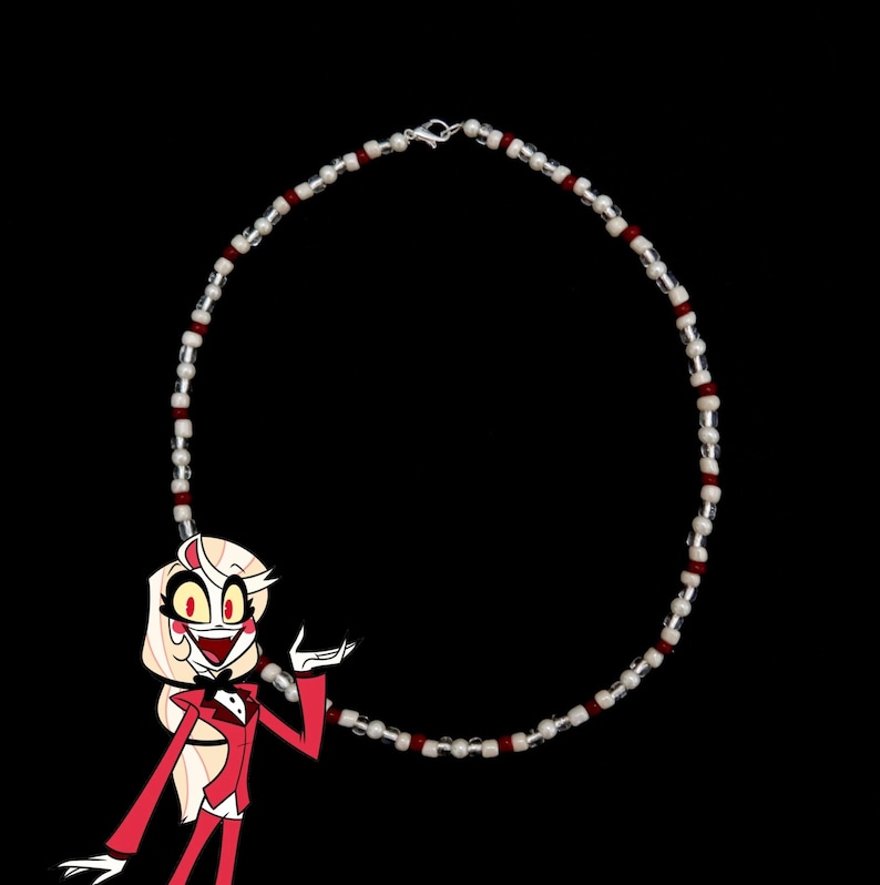 May include: A red and white beaded necklace with a silver clasp. The necklace is circular and has a repeating pattern of red and white beads.