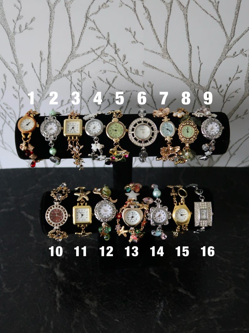 Puede incluir: Diecis&eacute;is relojes de pulsera variados expuestos en un soporte en T negro, numerados del uno al diecis&eacute;is. La colecci&oacute;n presenta diversos acabados met&aacute;licos, incluidos tonos dorados y plateados, con variados dijes decorativos, cuentas y formas de esfera.