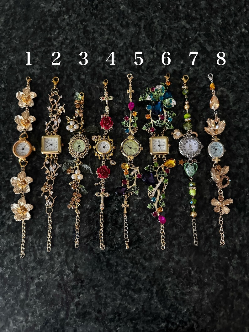 May include: Eight ornate, decorative wristwatches with various designs. Each watch features a different embellishment, including flowers, leaves, crosses, and gemstones. The watch faces are round or square, with Roman numerals. The watches are gold-toned and have delicate chains.