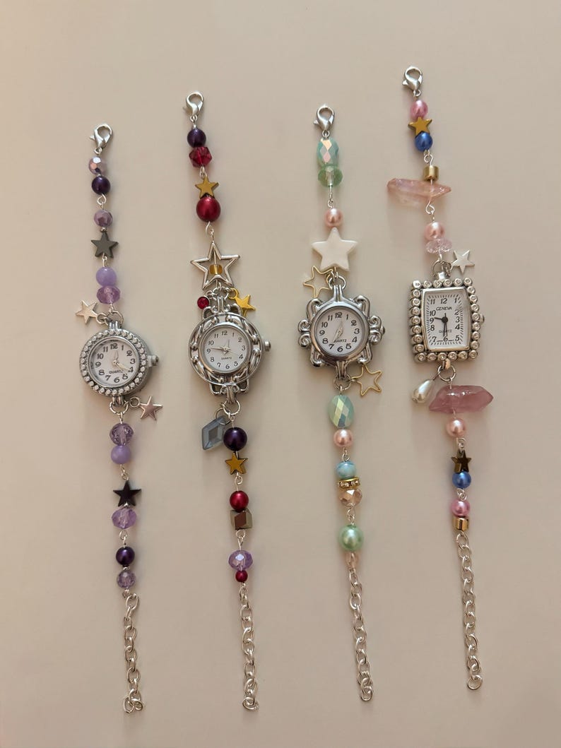 May include: Four decorative charm watches with silver-tone chains and beaded accents. Each watch features a different face shape and is adorned with colorful beads, stars, and crystals. The watch faces display the time.
